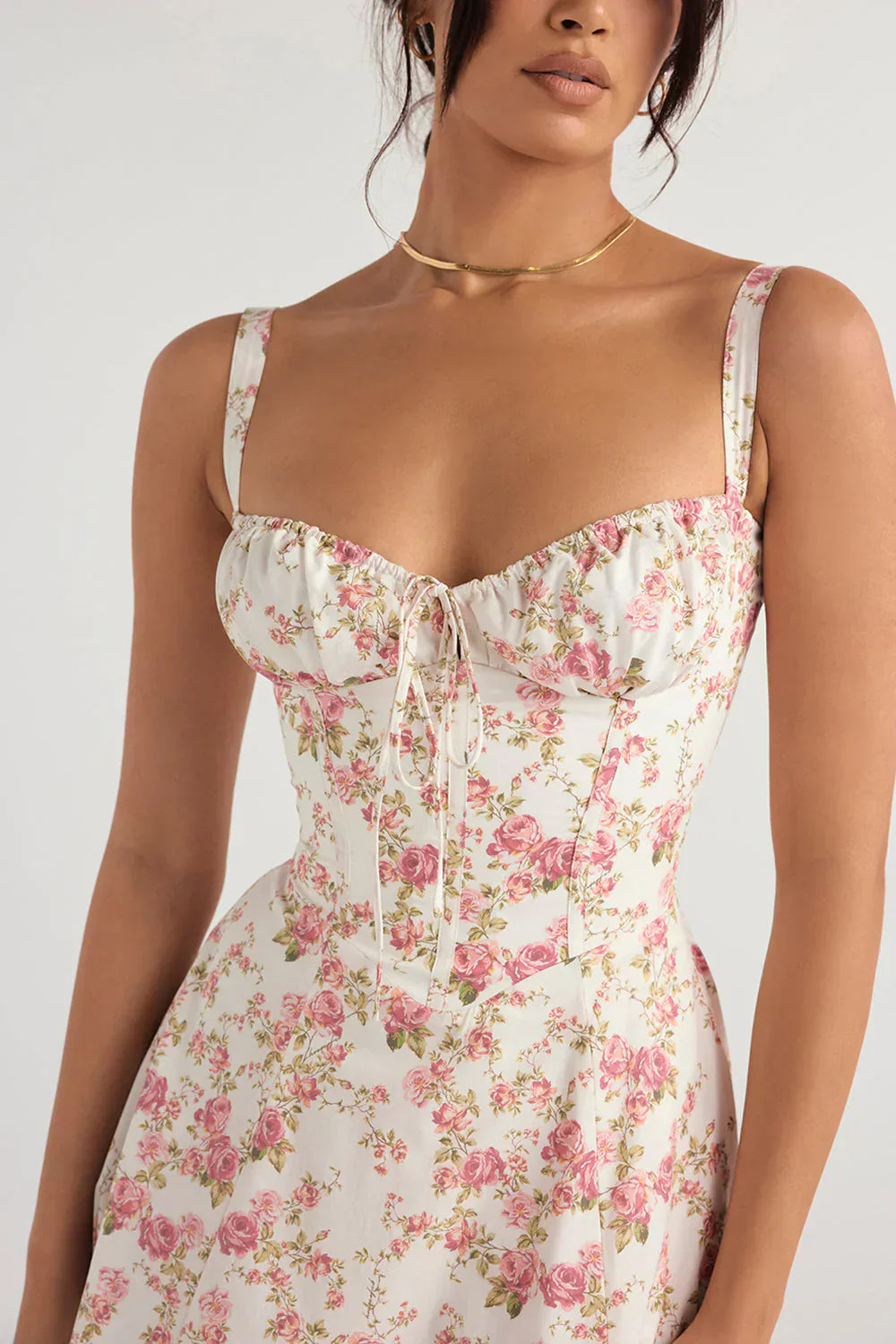 Woman wearing a floral dress with a plain background