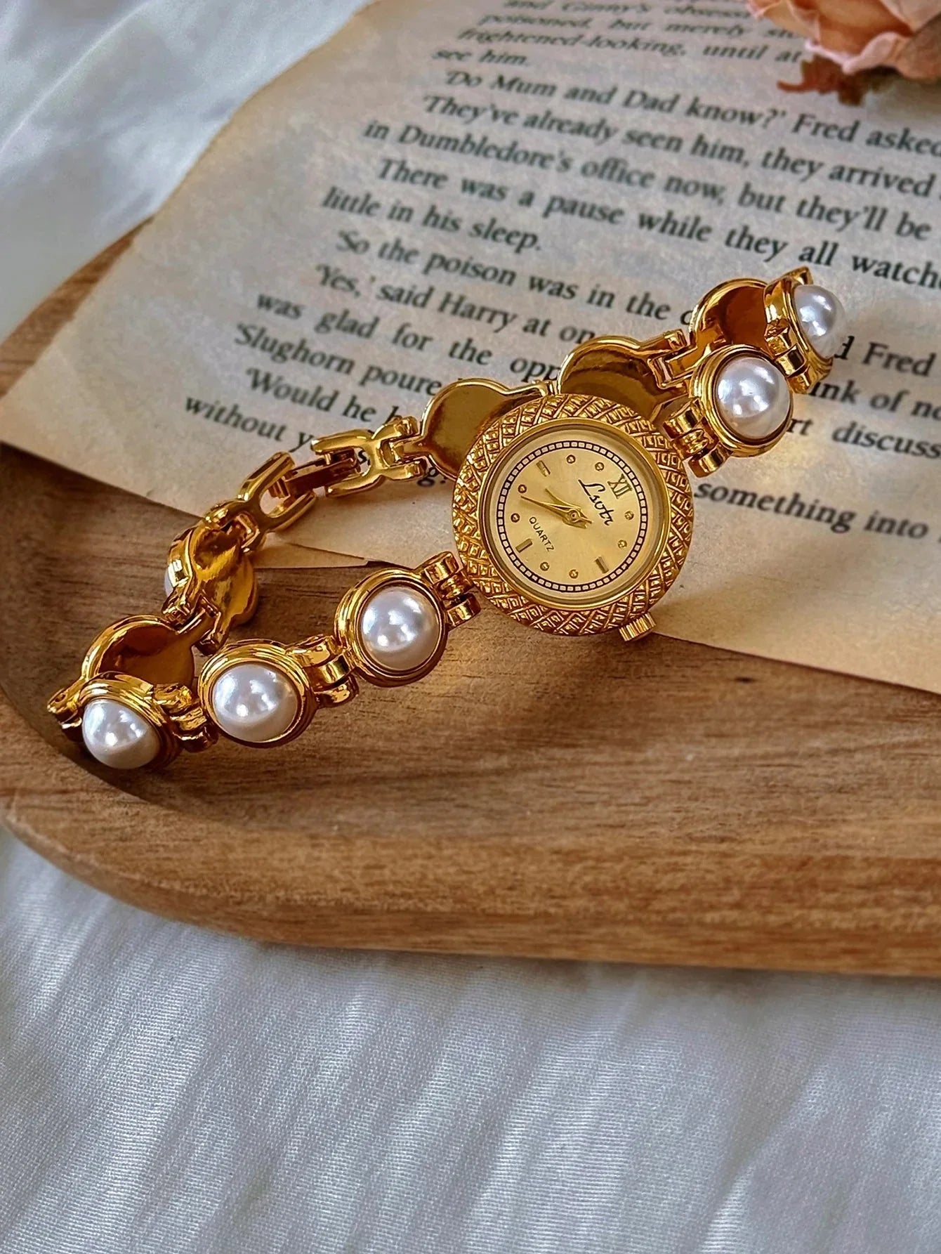 Gold bracelet with pearls on a wooden surface