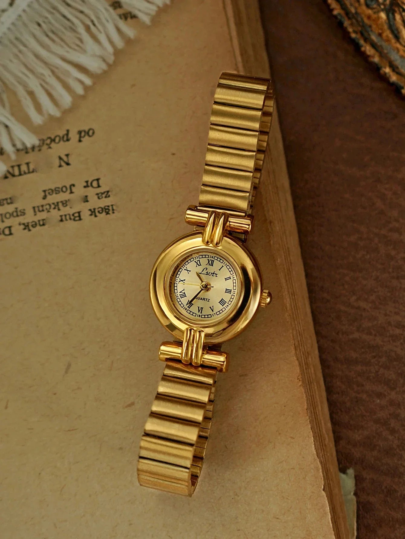 Gold wristwatch on a textured surface
