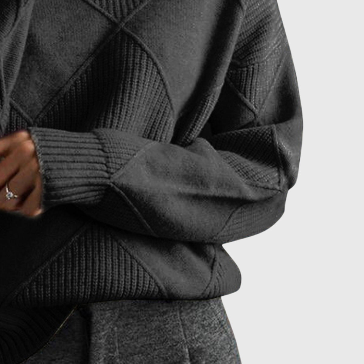 Charcoal grey knit turtleneck sweater with ribbed geometric panel detailing and long sleeves.