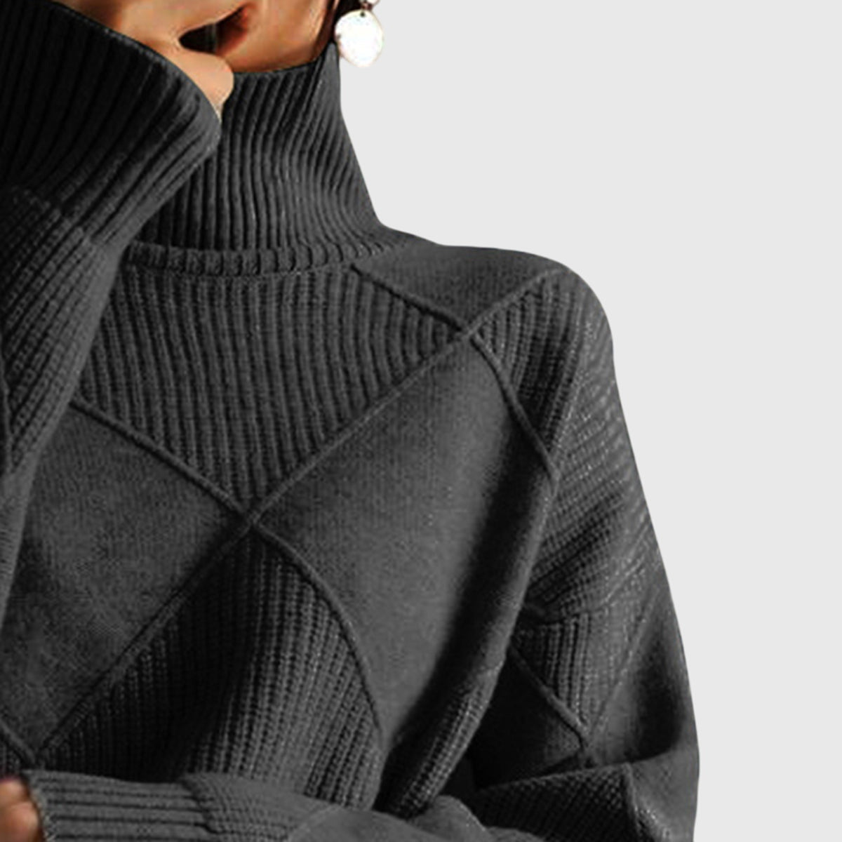 Black ribbed knit turtleneck sweater with geometric panel design and long sleeves.