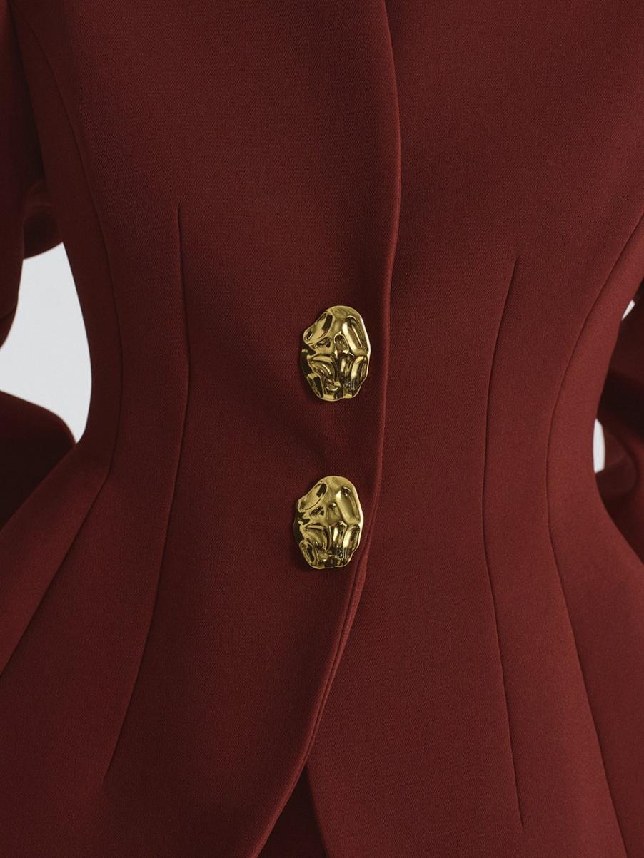 Women's burgundy peplum blazer and trousers set — close-up detail