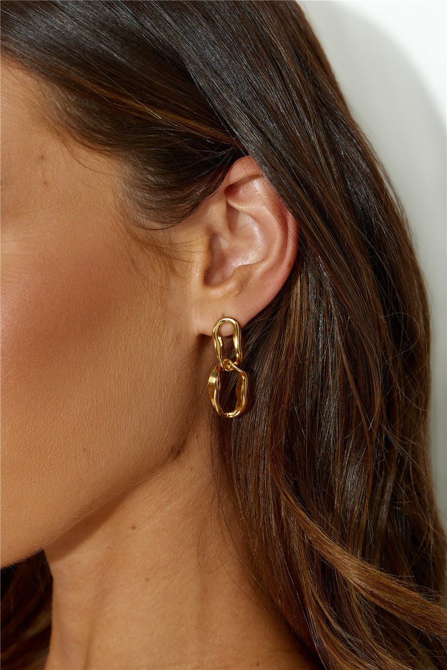 Women's gold dangle earrings — detail shot