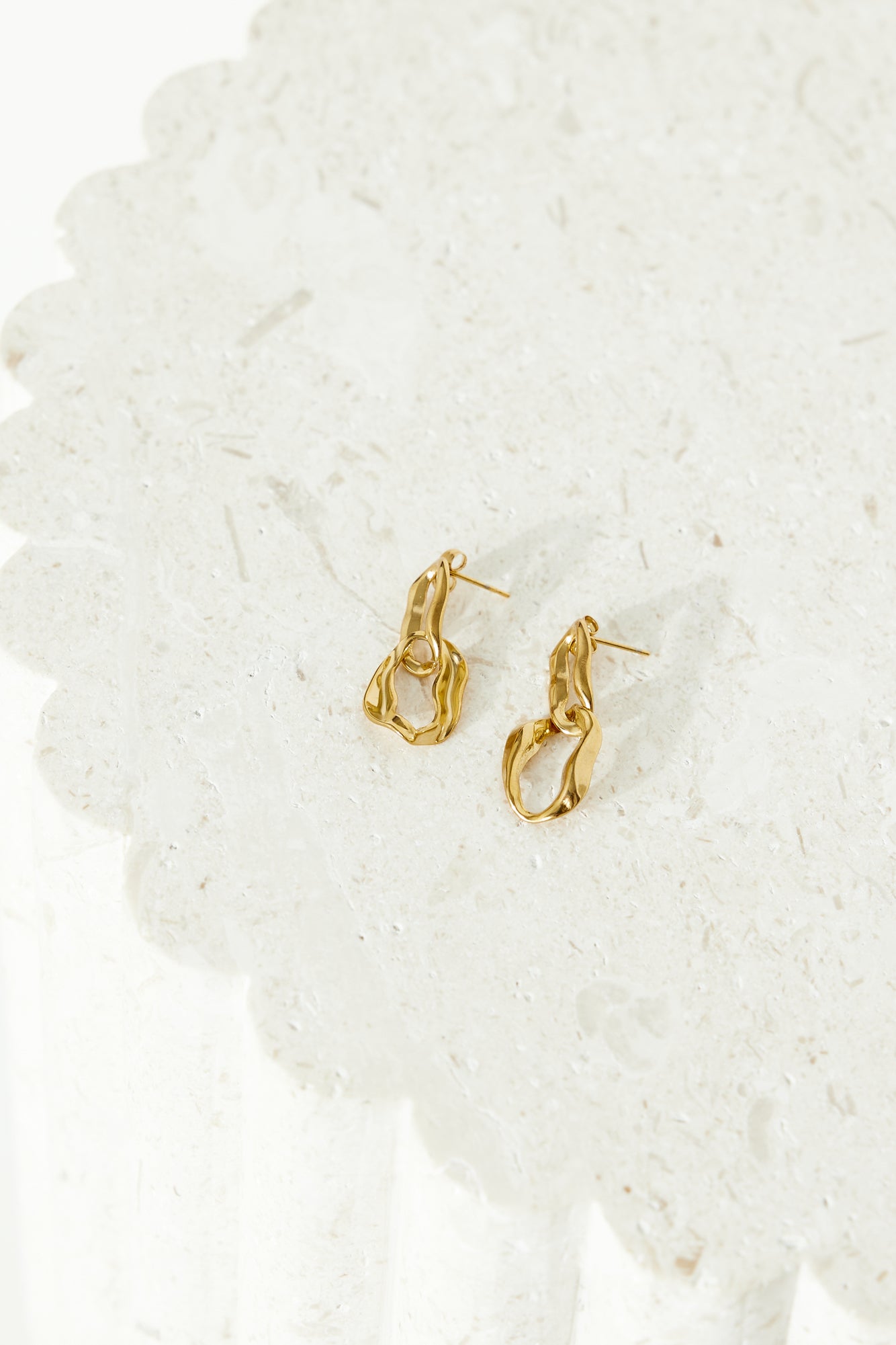 Women's gold dangle earrings — detail shot