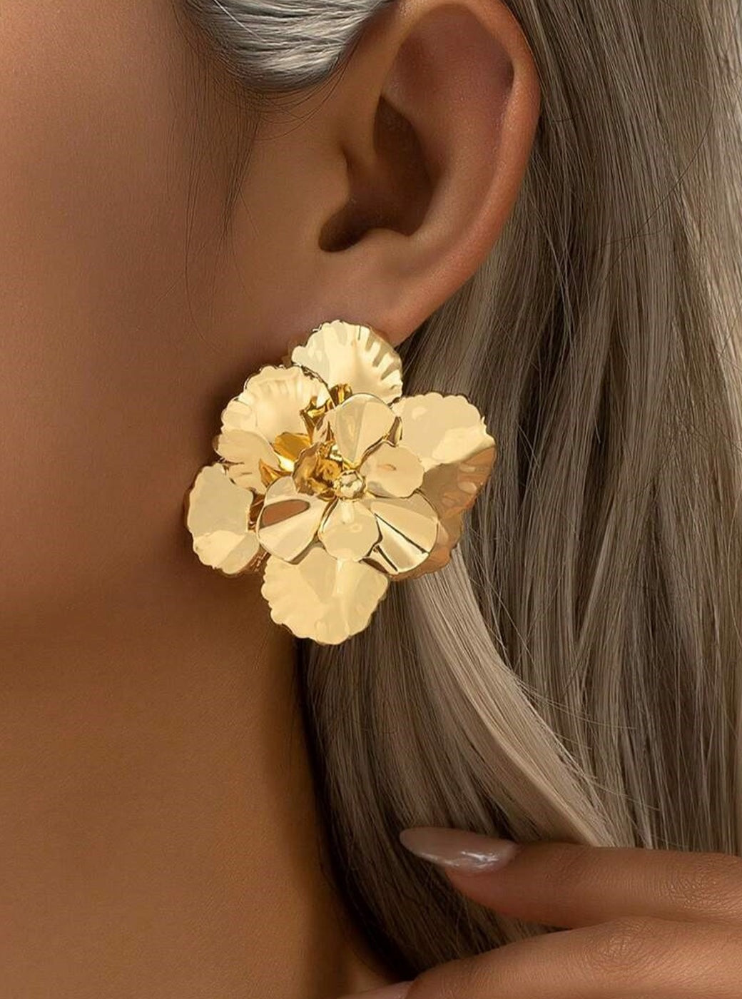 Women's gold flower earrings — worn