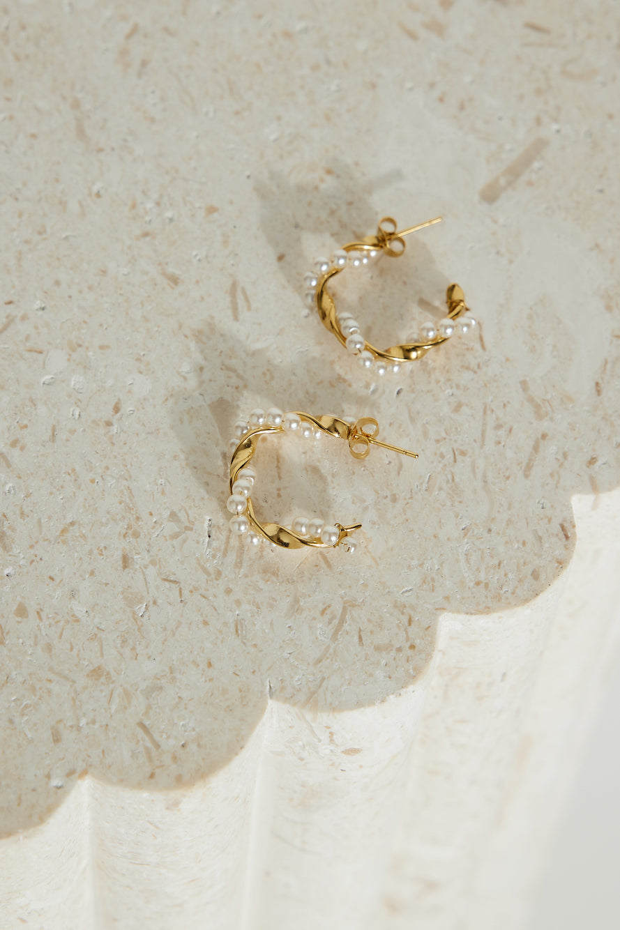 Women's gold pearl hoop earrings — detail shot