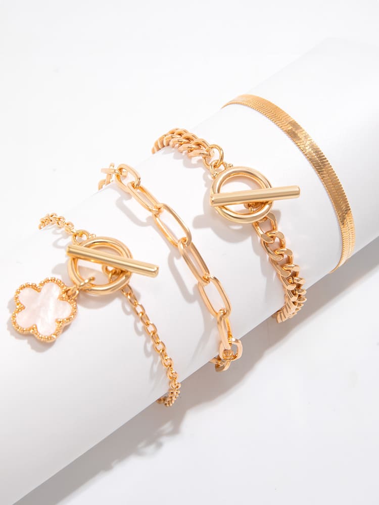 Women's gold snake chain clover charm bracelet — worn on wrist