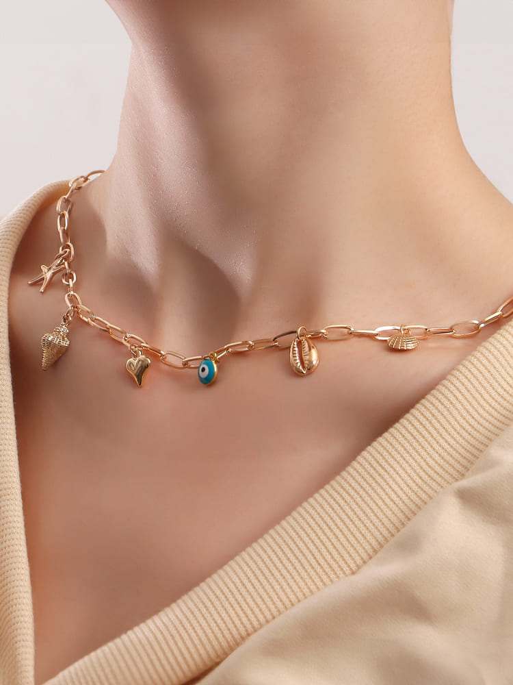 Women's gold spiral shell and seastar necklace — side detail