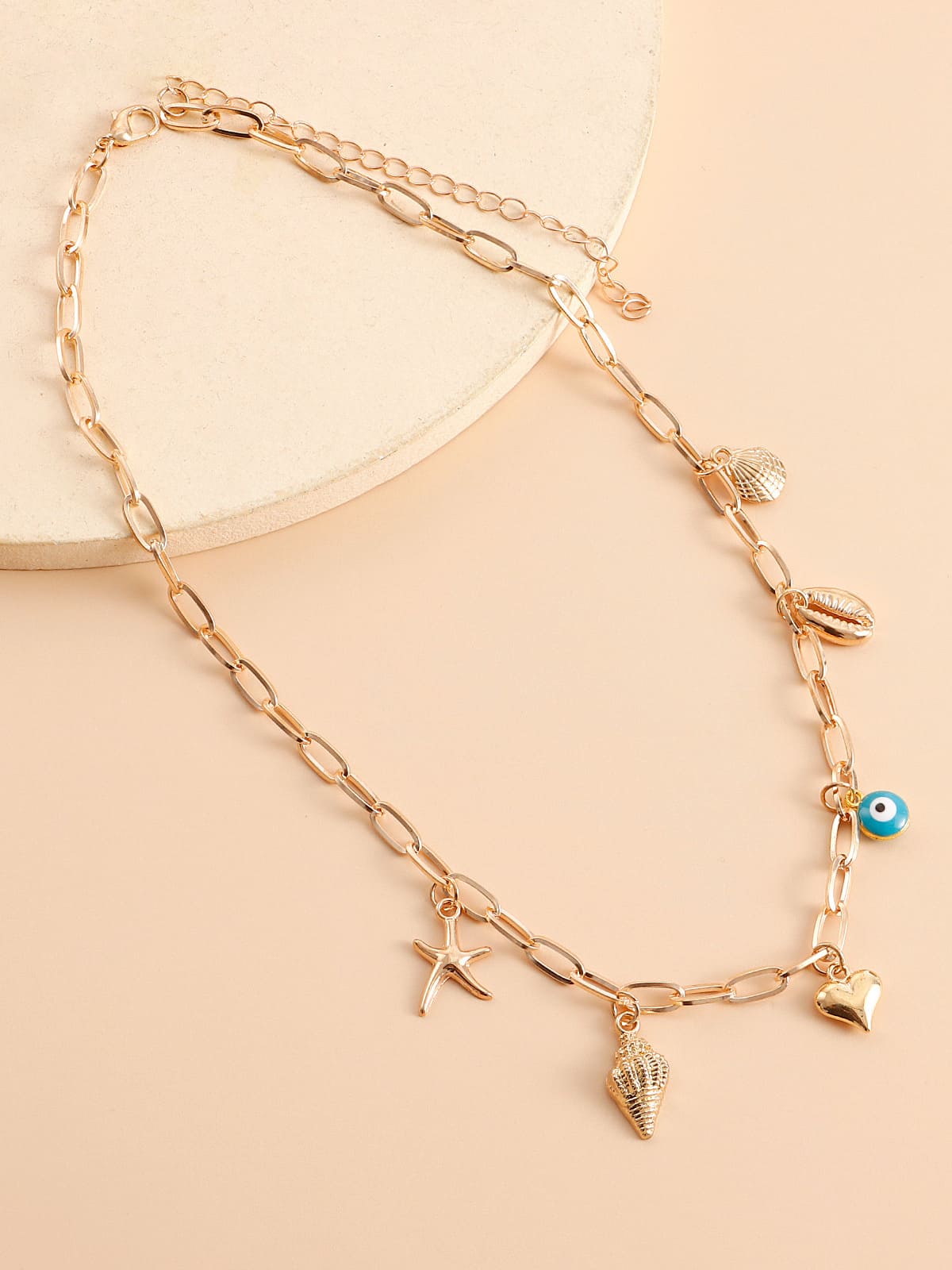 Women's gold spiral shell and seastar necklace — alternate angle