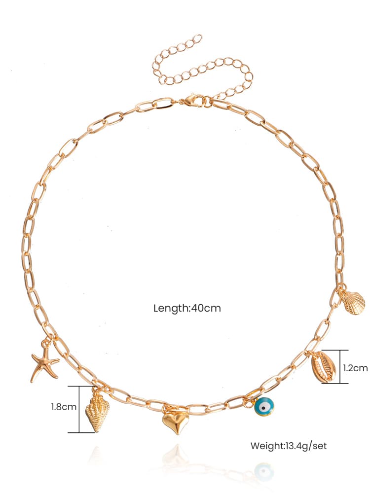 Women's gold spiral shell and seastar necklace — close-up detail