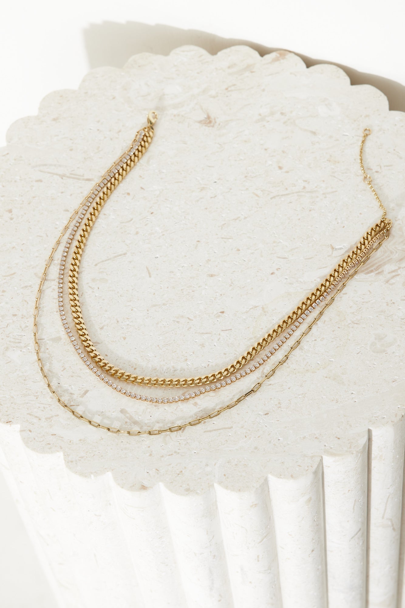 Women's gold triple chain necklace — detail shot