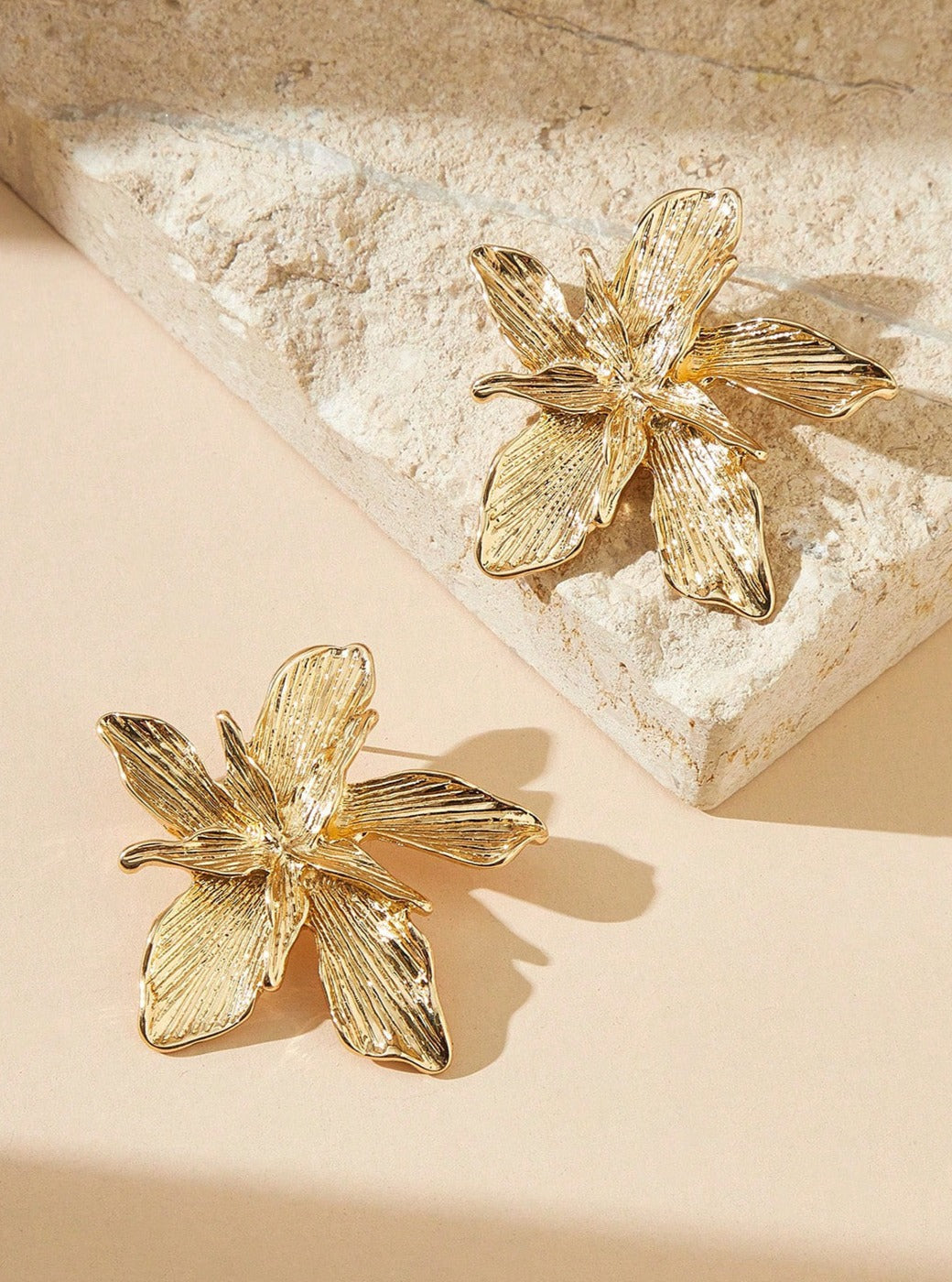 Women's gold metal flower earrings — worn